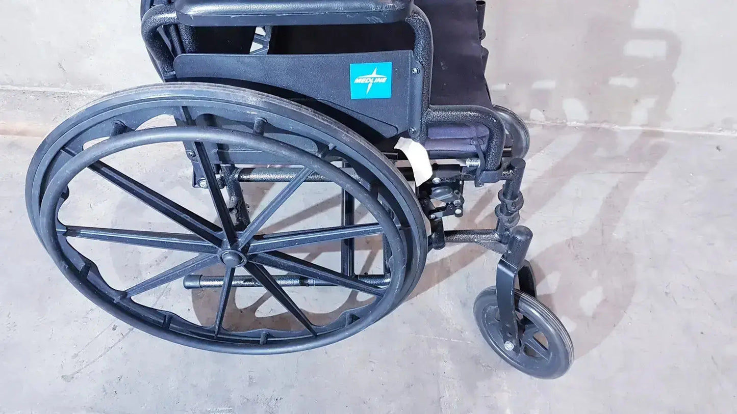 Back side of medline guardian k1 lightweight black metal wheelchair with teal logo on the compact seat backrest