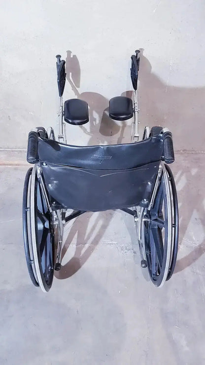 Black leather-backed medline k1206n22e manual wheelchair with silver metal frame and black padded seat cushions