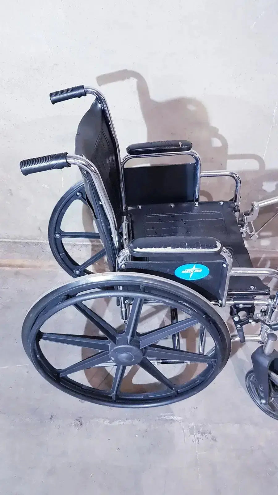 Black metal medline k1206n22e manual wheelchair with padded seat and large spoked wheels for adult use