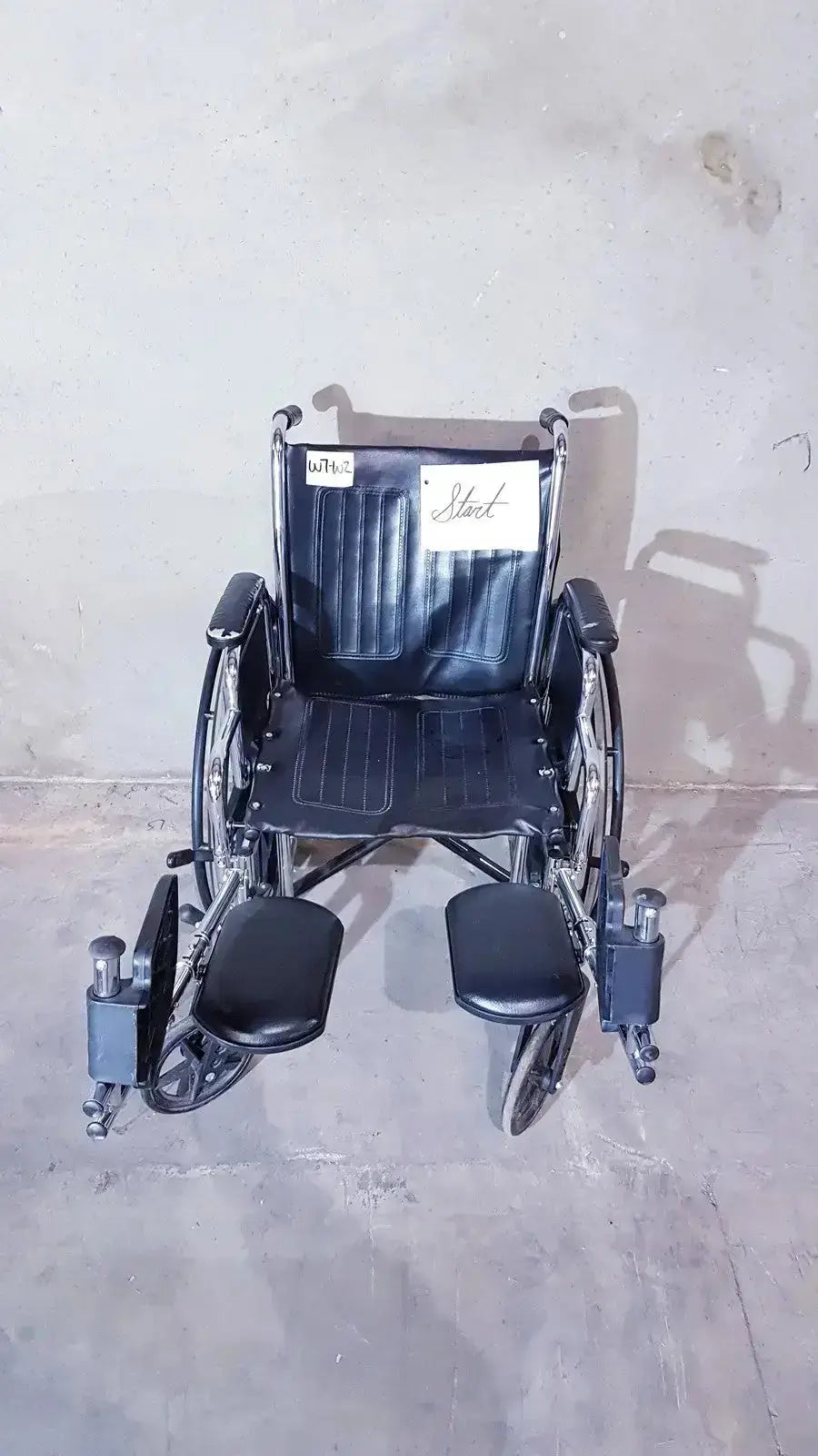 Black leather-backed medline k1206n22e manual wheelchair with metal frame and footrests shown from back side