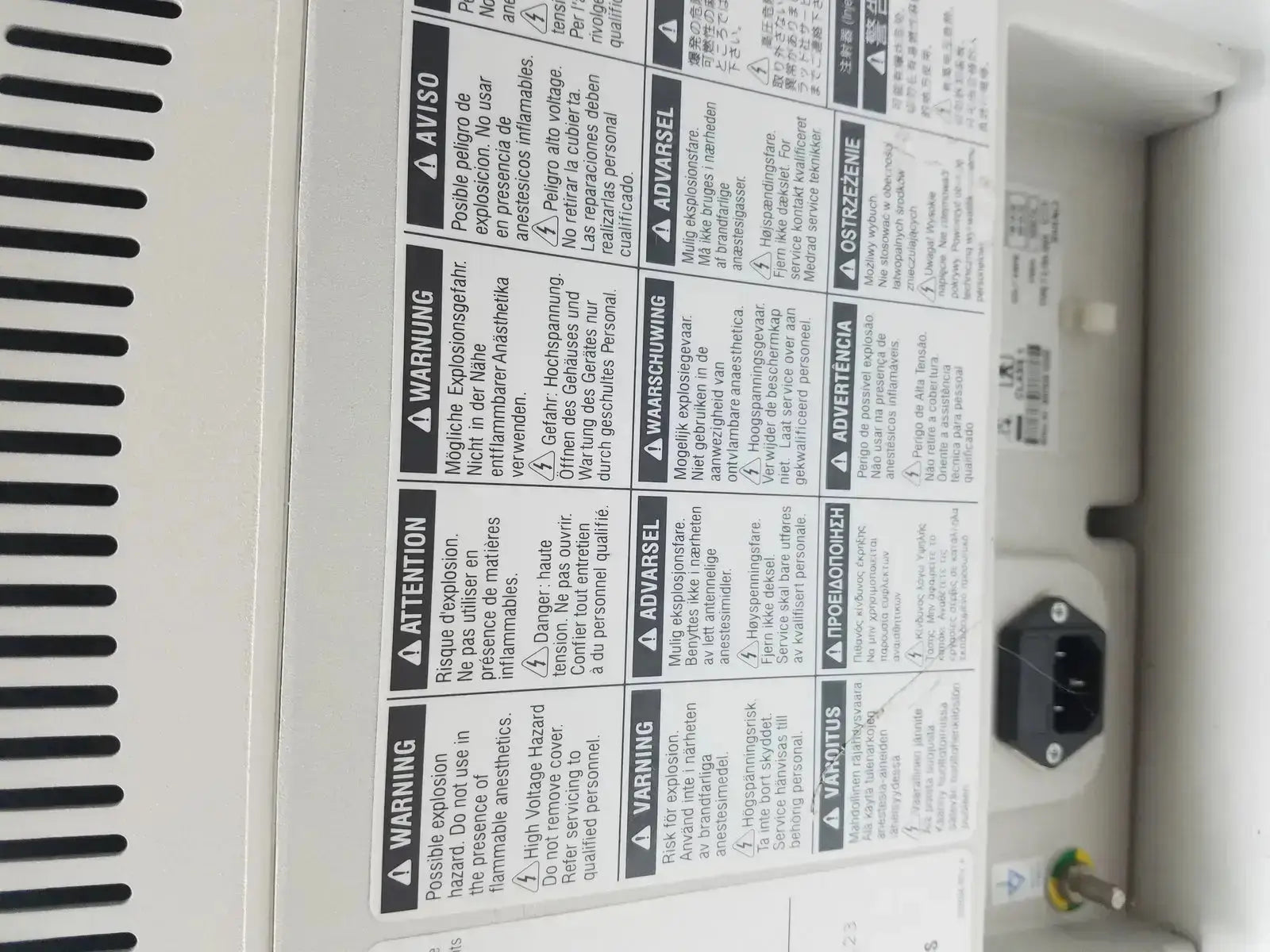 White plastic medrad stellant ct power supply showing black power plug and multilingual safety warning labels on back side