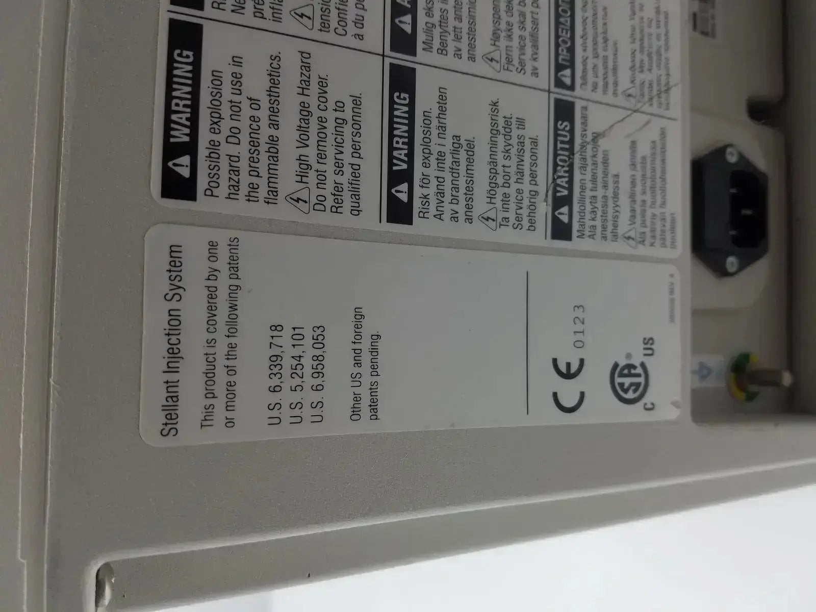 White plastic label with black text and regulatory markings on the back of medrad stellant ct power supply unit