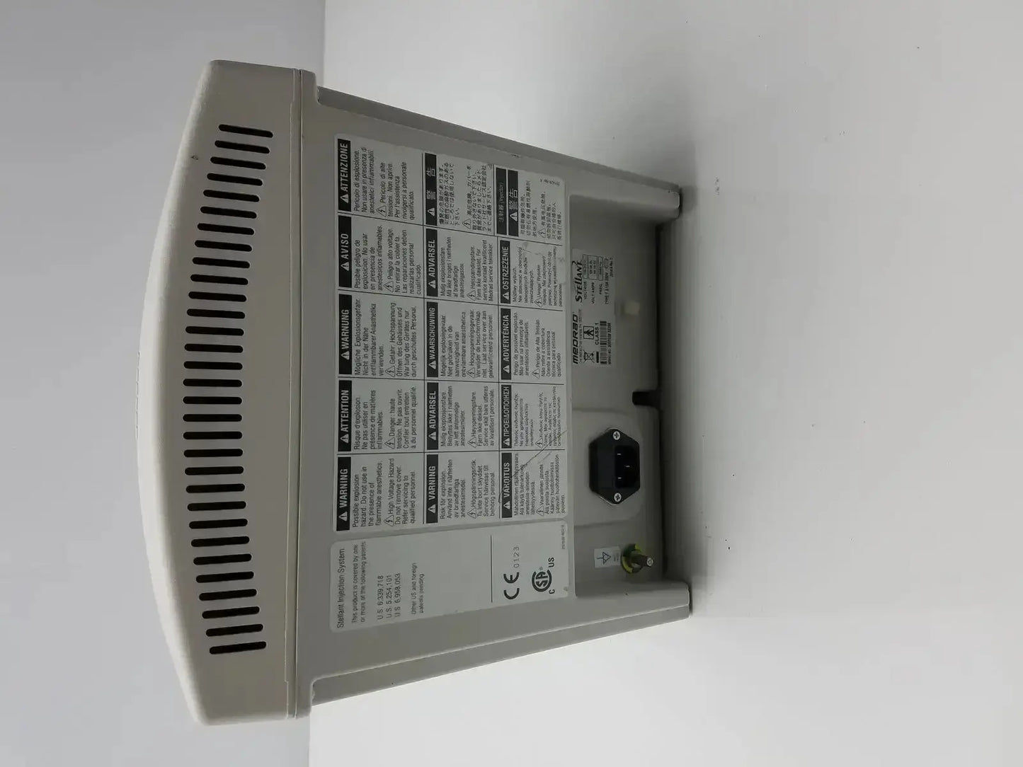 Gray plastic medrad stellant ct power supply with vented side panel and warning labels for medical use