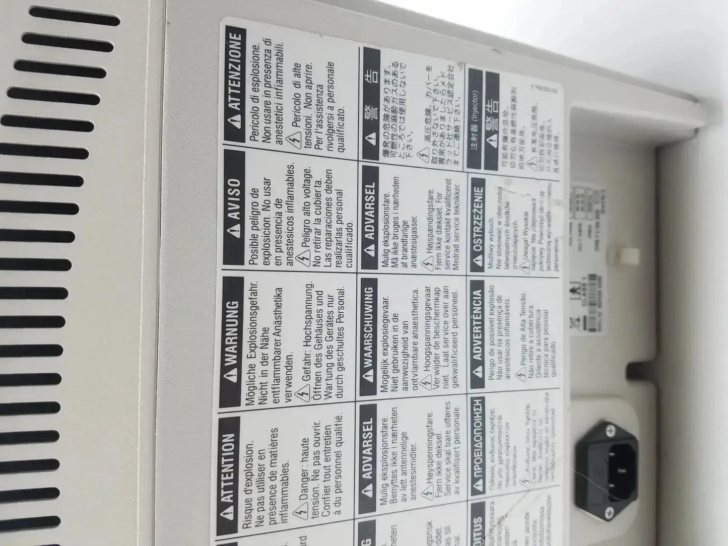 White plastic medrad stellant ct power supply with black multilingual warning labels and power plug on the back side