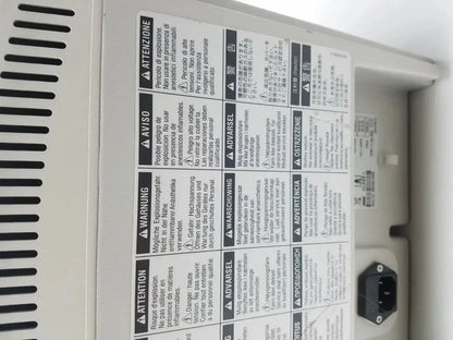 White plastic medrad stellant ct power supply with black multilingual warning labels and power plug on the back side