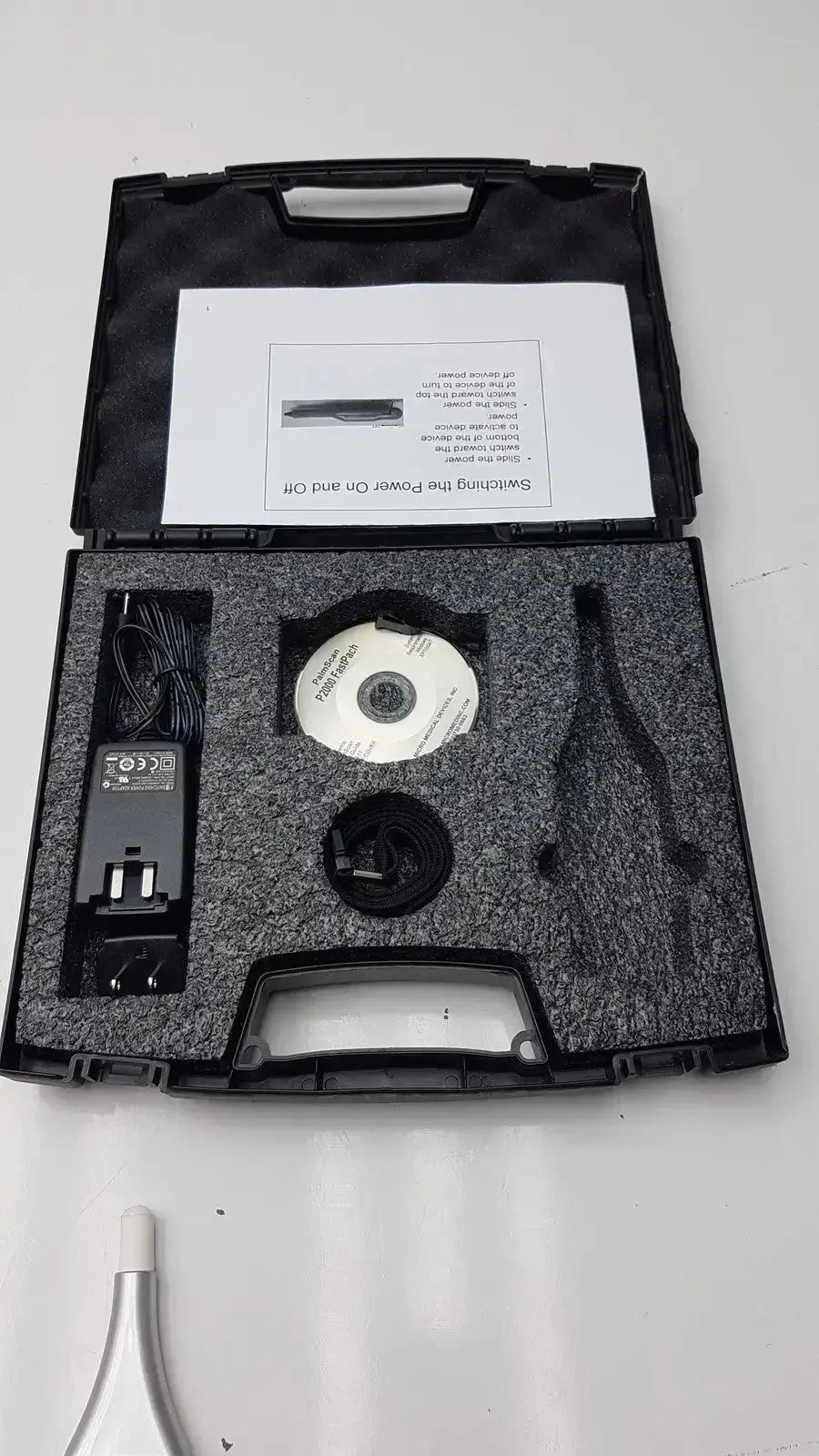 Black hard-shell carrying case with foam inserts holding micro medical devices palmscan p2000 fastpach pachymeter accessories
