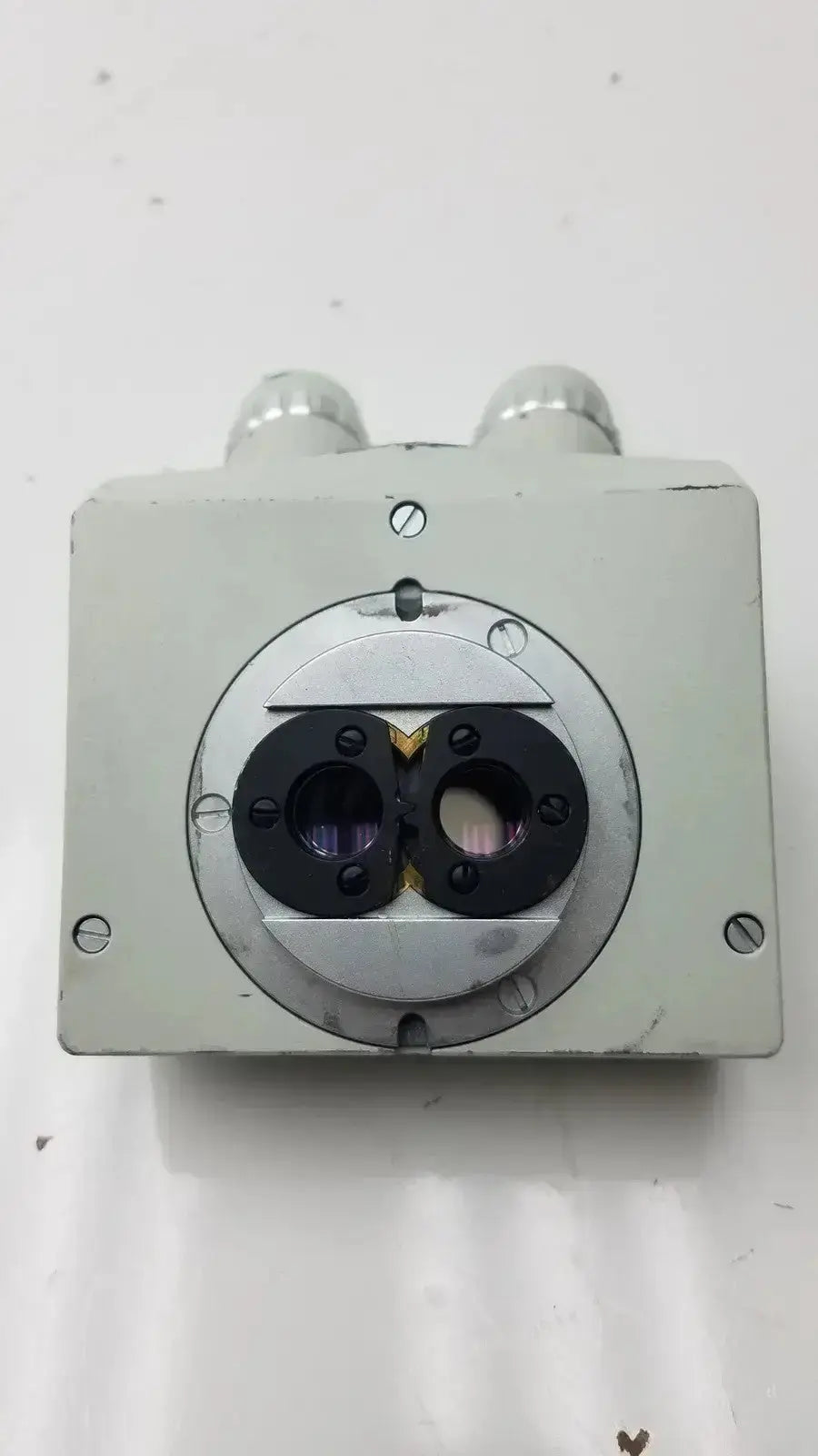 Silver metallic microscope binocular head p16x with two circular lens ports and cylindrical protrusions on top