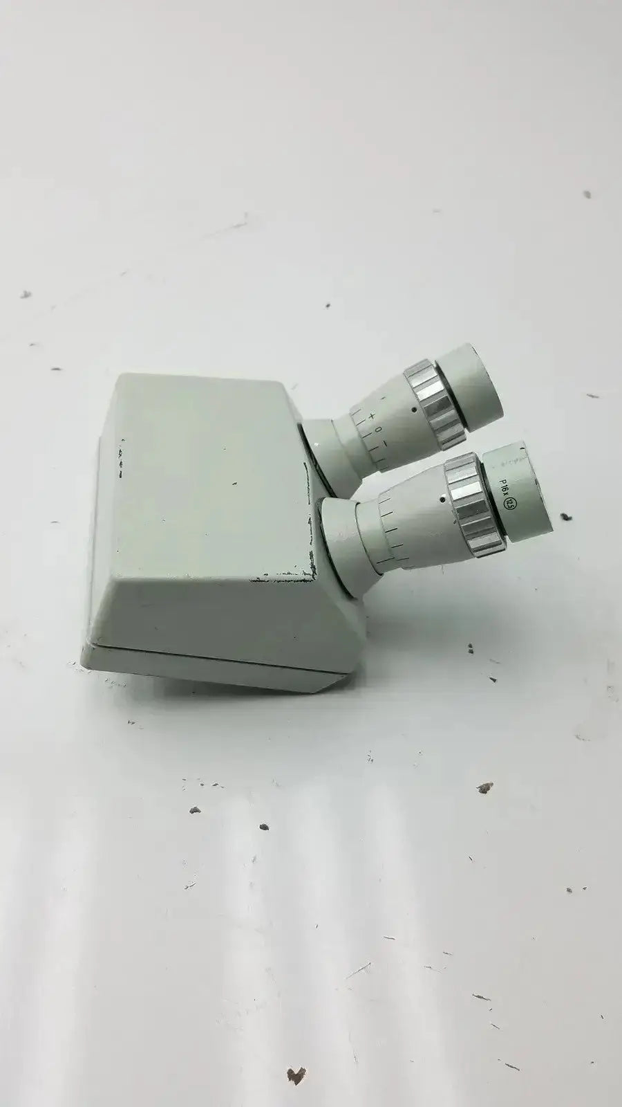 Light gray microscope binocular head p16x with dual eyepieces and metallic adjustment rings for precision viewing