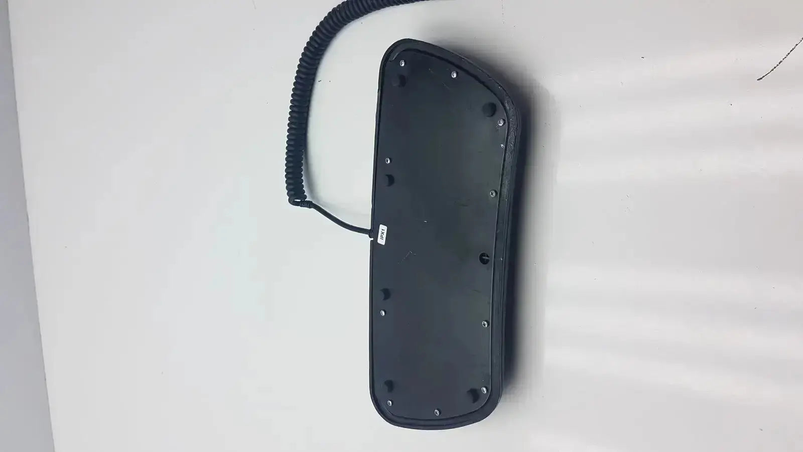 Black plastic telephone handset with coiled cord and screw holes on back for midmark 647 podiatry chair foot control