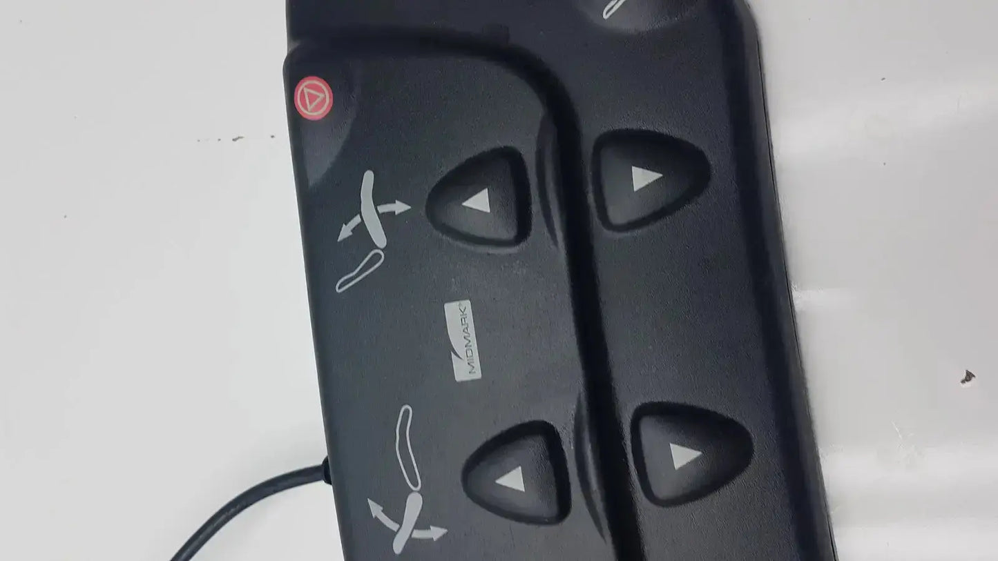Black plastic midmark 647 podiatry chair foot control panel with four triangular buttons and red circular button