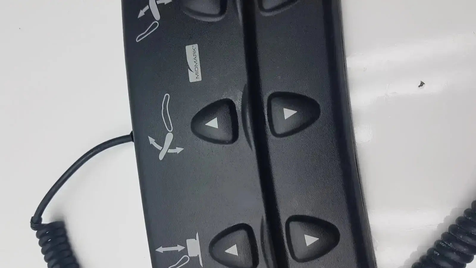 Black plastic podiatry chair foot control with triangular buttons and white directional icons for midmark 647 chair