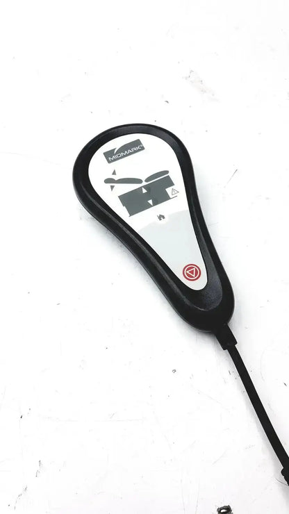 Black plastic Midmark exam table hand remote control with white label and red button for table hand operation