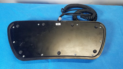 Black plastic keyboard base of midmark qe ipx1 wired foot controller with coiled black cable and silver screws for medical equipment reuse