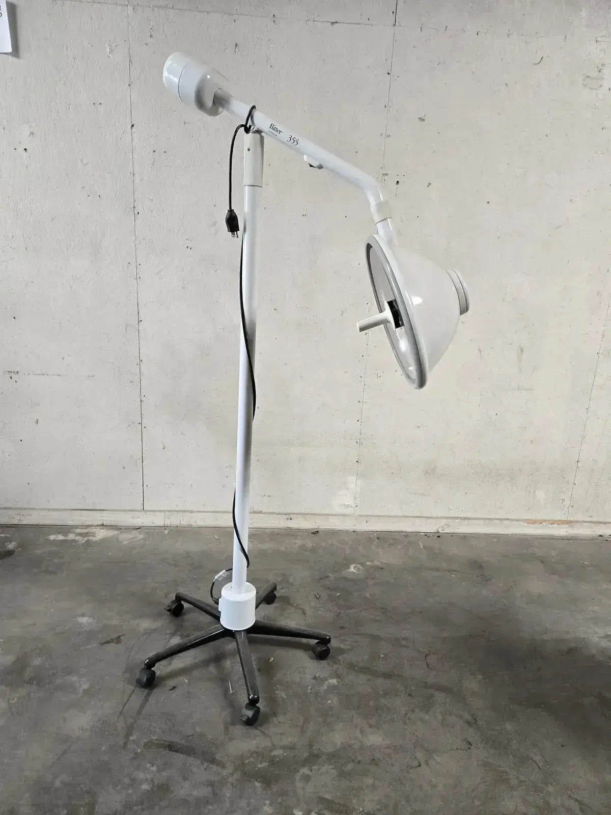 White adjustable midmark ritter 355-022 medical lamp with curved arm and rolling stand for minor surgery procedure
