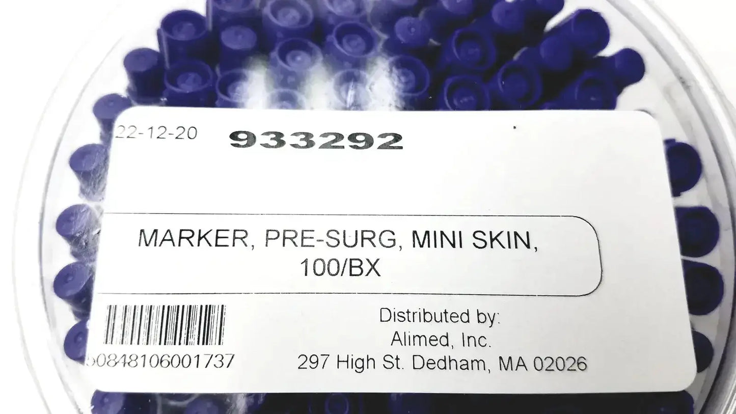 A clear plastic container holds multiple dark blue cylindrical mini pre-surgery skin markers with scurb resistant ink