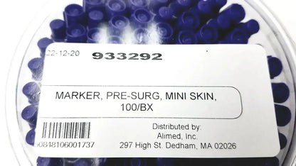 A clear plastic container holds multiple dark blue cylindrical mini pre-surgery skin markers with scurb resistant ink