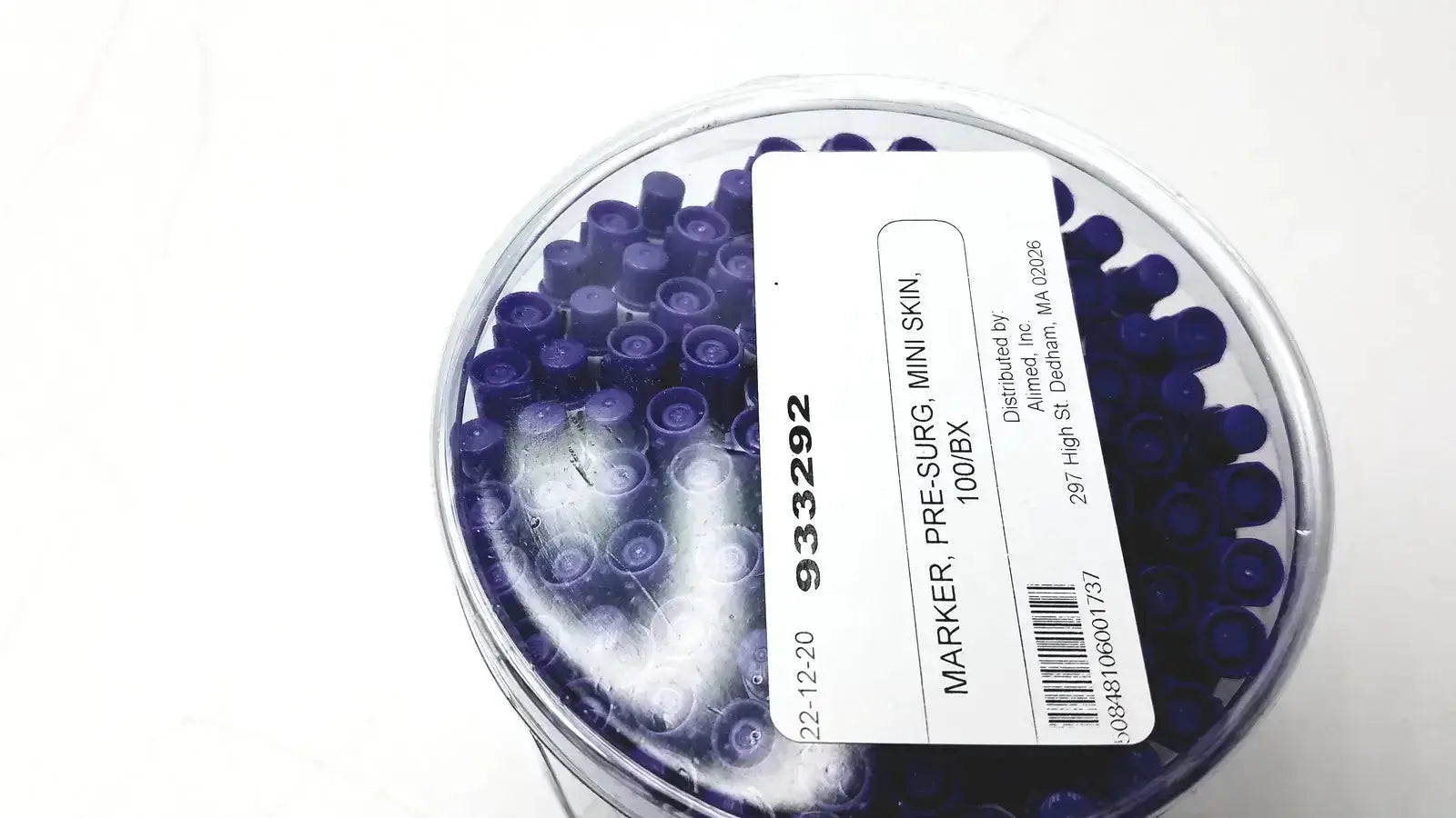 A clear plastic container filled with 100 dark blue mini pre-surgery skin markers with scurb resistant ink