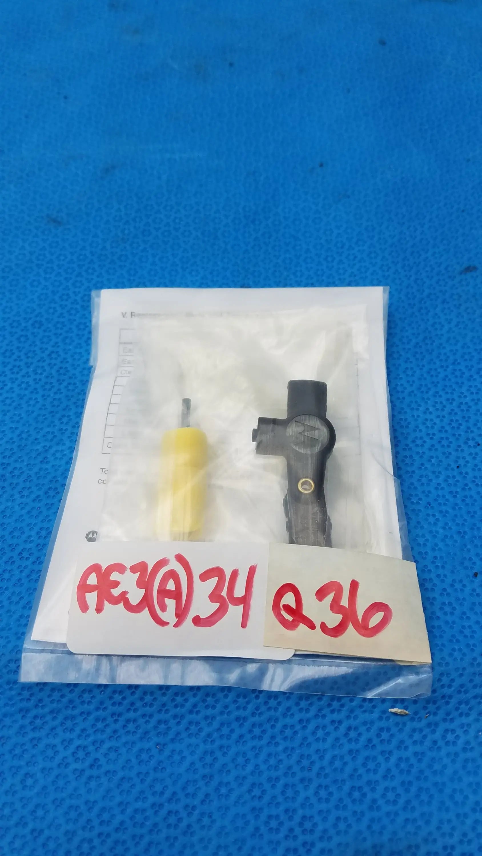 Black plastic automotive sensor with yellow handled tool in clear packaging from motorola rln6230a extreme noise kit