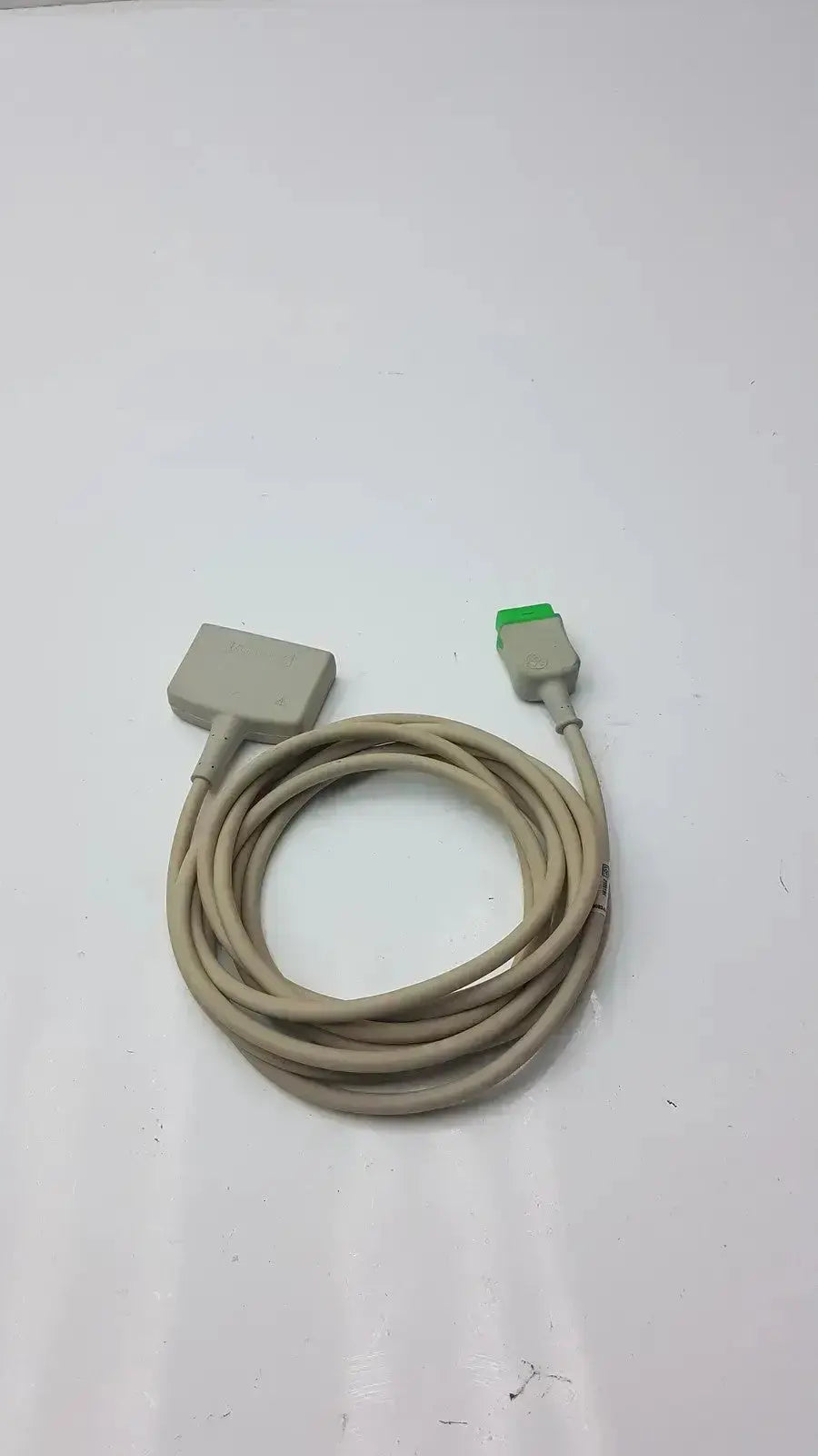 Beige coiled multi-link ecg ttrunk cable by ge with rectangular gray and smaller green-gray connectors for reliable connections