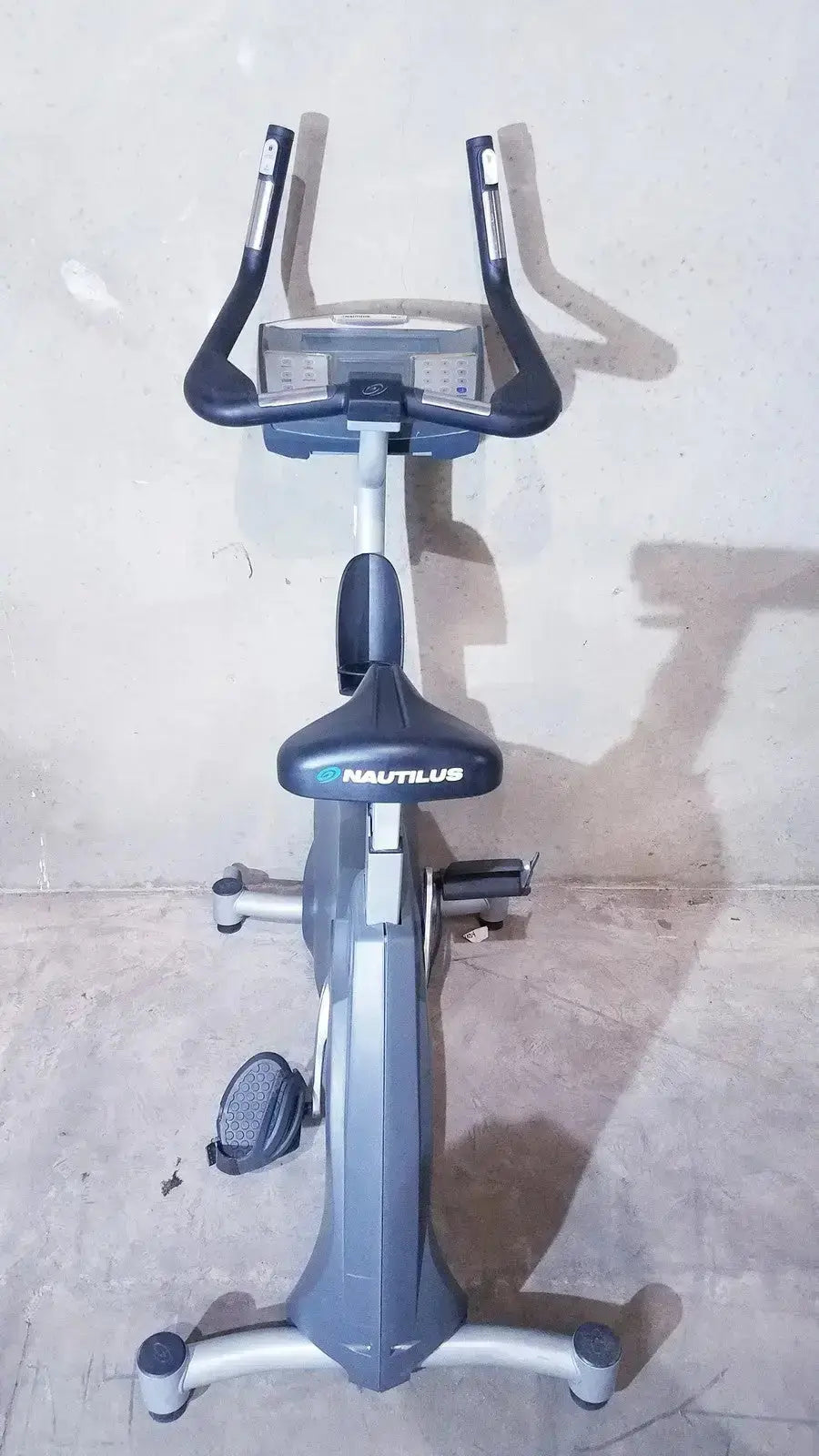 Gray and black nautilus schwinn blue indoor cycling bike with digital display panel for commercial use