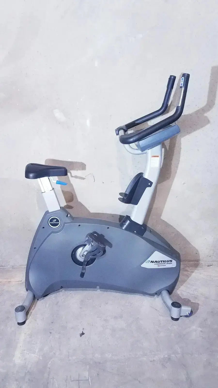 Gray nautilus exercise bike with black handlebars and seat from schwinn blue indoor cycling bike commercial series