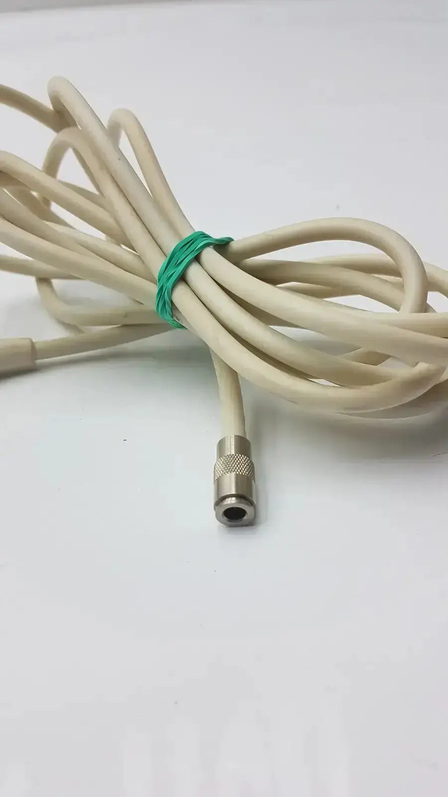 Beige nbp sensor probe cable with metallic threaded straight plug secured by green tie for accurate readings