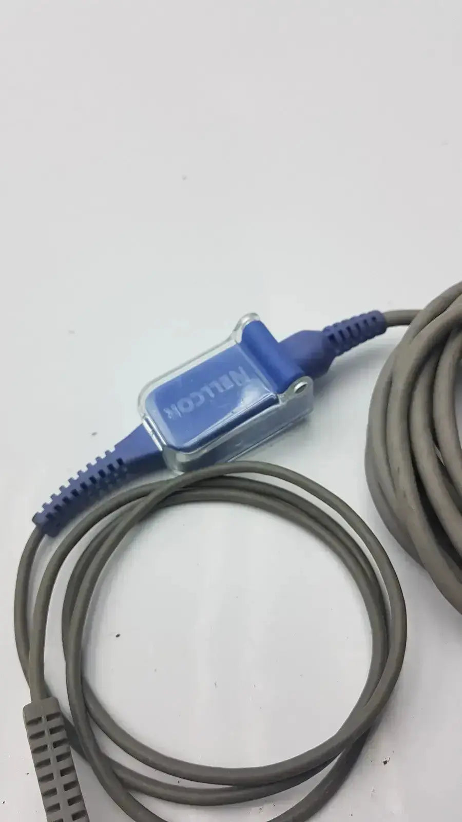 Blue and clear plastic finger clip extension cable with gray coiled cord used medical equipment for sale