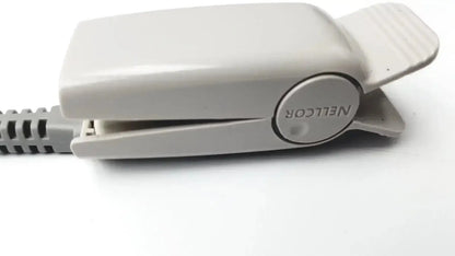 A beige plastic nellcor original spo2 adapter cable clip with rounded ergonomic design and circular brand logo on the side