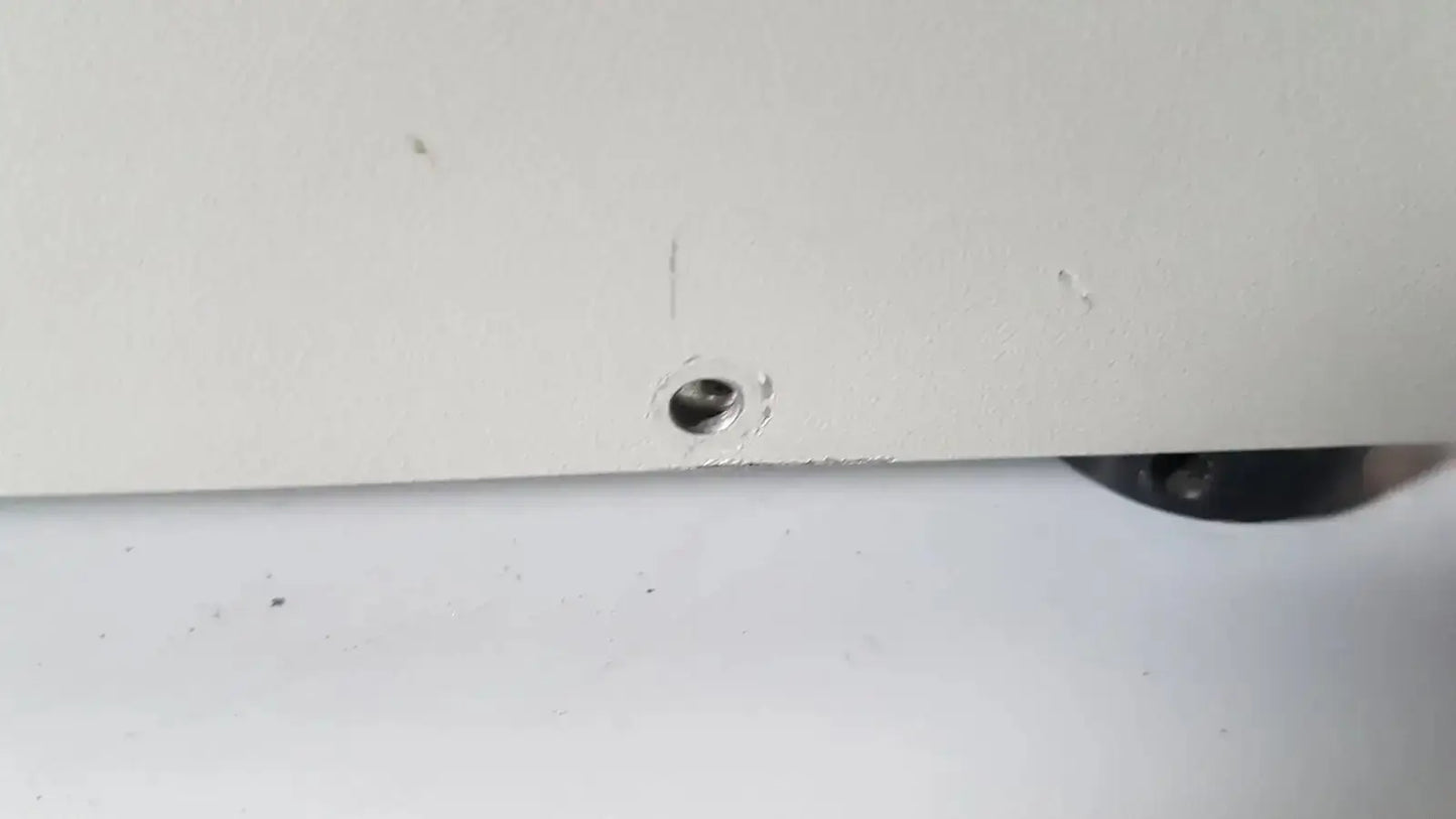 A small metallic screw embedded in the white plastic edge of the netzsch gmbh sta 409 pc luxx simultaneous thermal analyzer