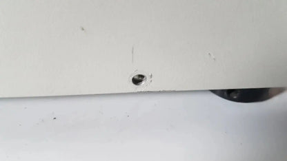 A small metallic screw embedded in the white plastic edge of the netzsch gmbh sta 409 pc luxx simultaneous thermal analyzer