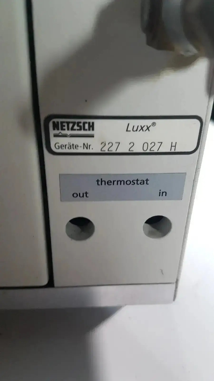 Back view of the white netzsch luxx thermostat with labeled out and in ports for simultaneous thermal analyzer use