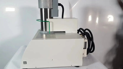 White laboratory simultaneous thermal analyzer with metallic cylindrical column and black coiled cables by netzsch gmbh