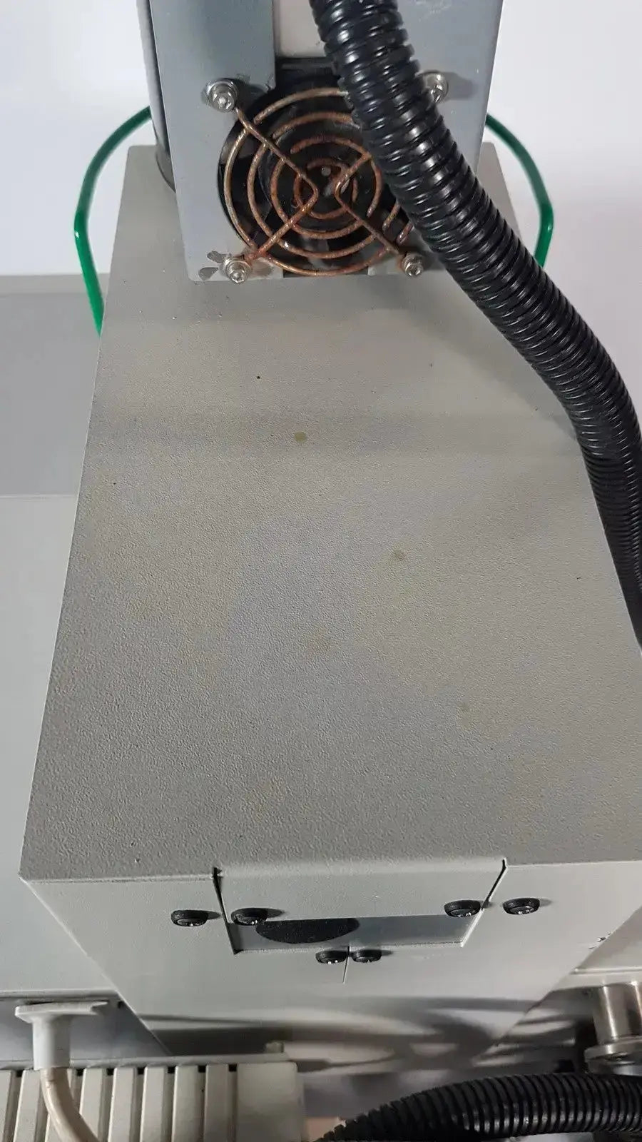 Gray industrial simultaneous thermal analyzer with copper-colored fan and black corrugated tubing by Netzsch GmbH