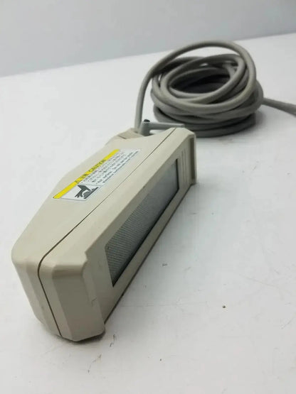 Beige plastic nihon kohden ls-703a photic stimulator handheld device with coiled gray cable and yellow warning label