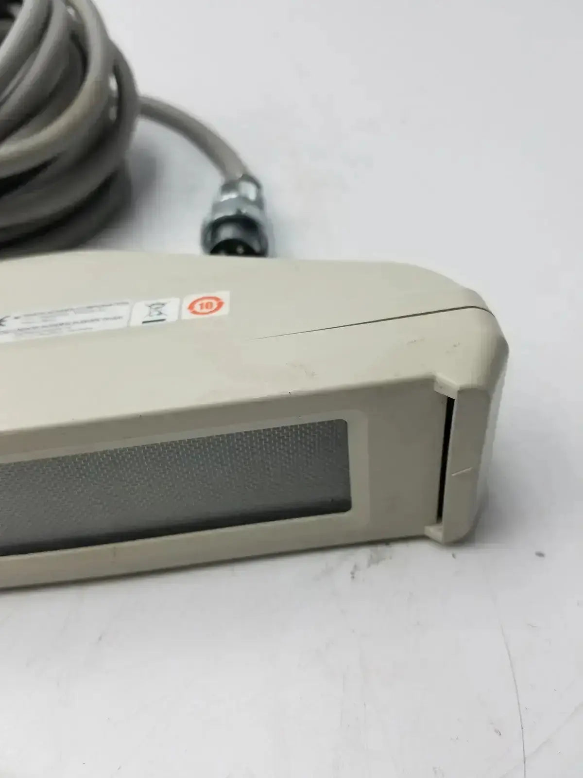Beige plastic nihon kohden ls-703a photic stimulator with a gray textured panel and coiled gray cable handheld device