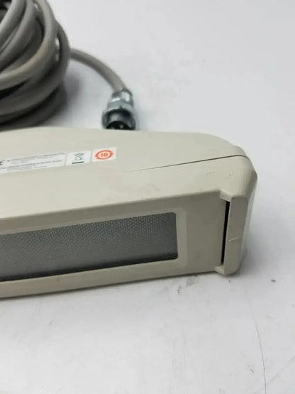 Beige plastic nihon kohden ls-703a photic stimulator with a gray textured panel and coiled gray cable handheld device