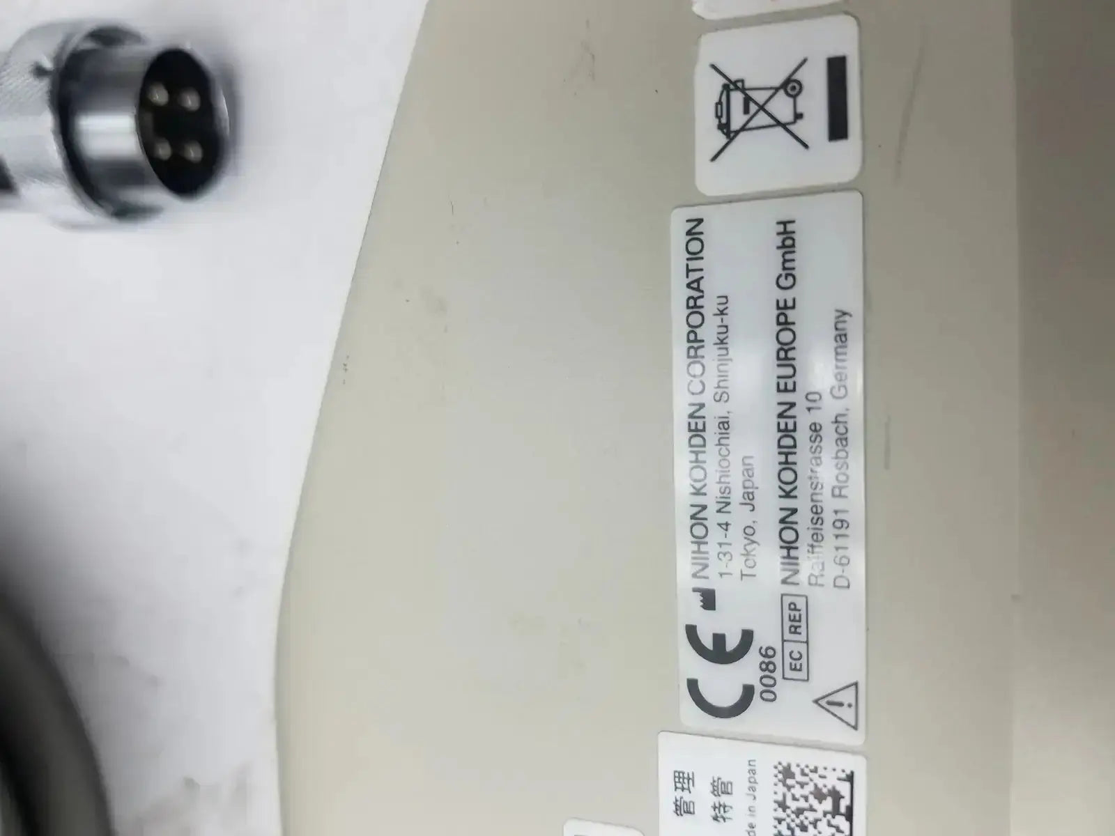 Beige plastic label with black text on nihon kohden ls-703a photic stimulator showing manufacturer details