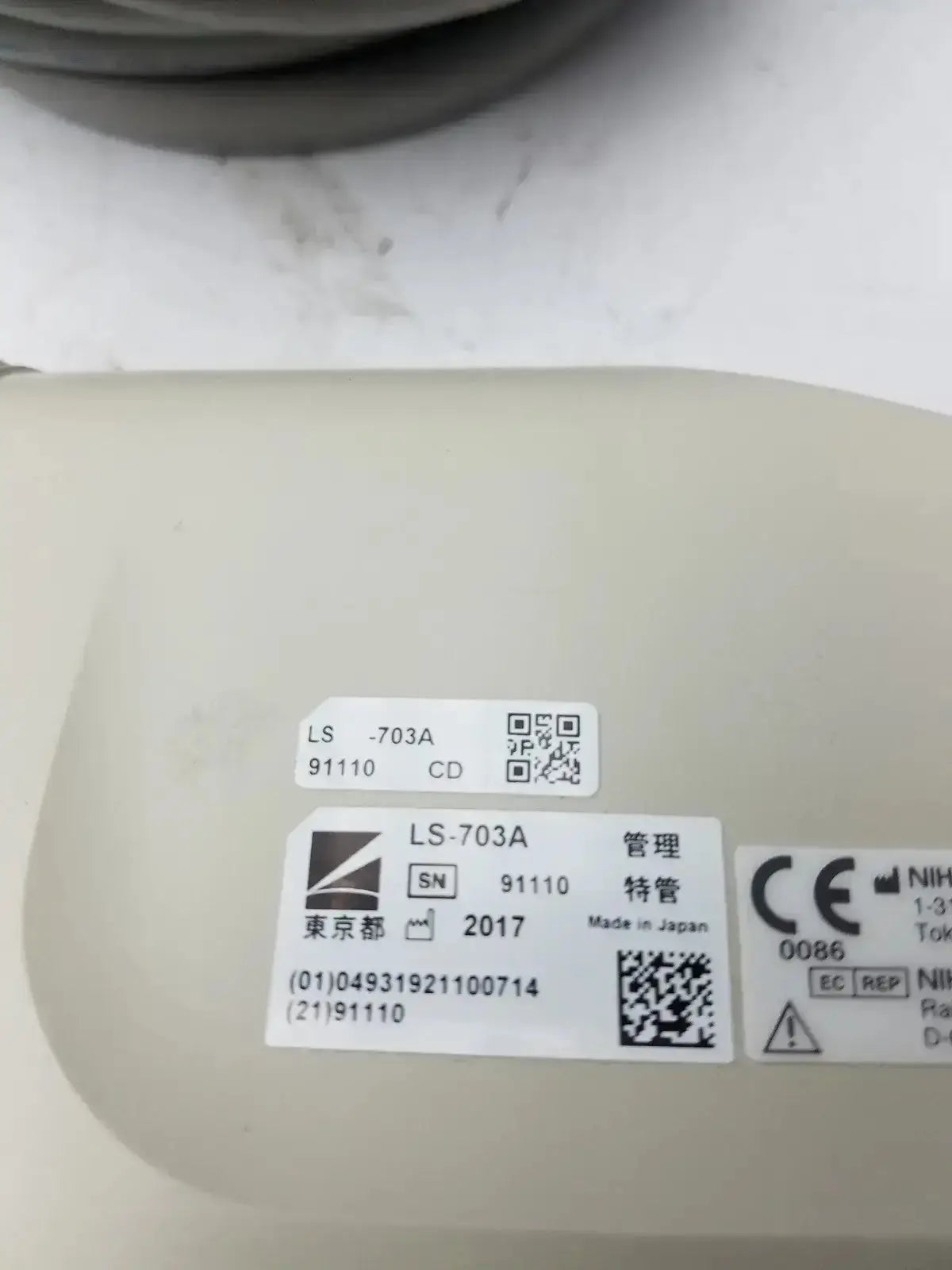 Beige plastic nihon kohden ls-703a photic stimulator with white labels featuring black text and qr codes made in japan
