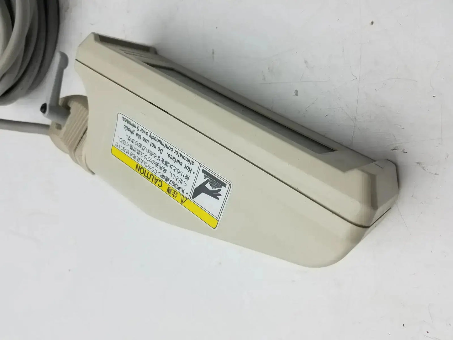 Beige plastic nihon kohden ls-703a photic stimulator with coiled gray cable and warning label