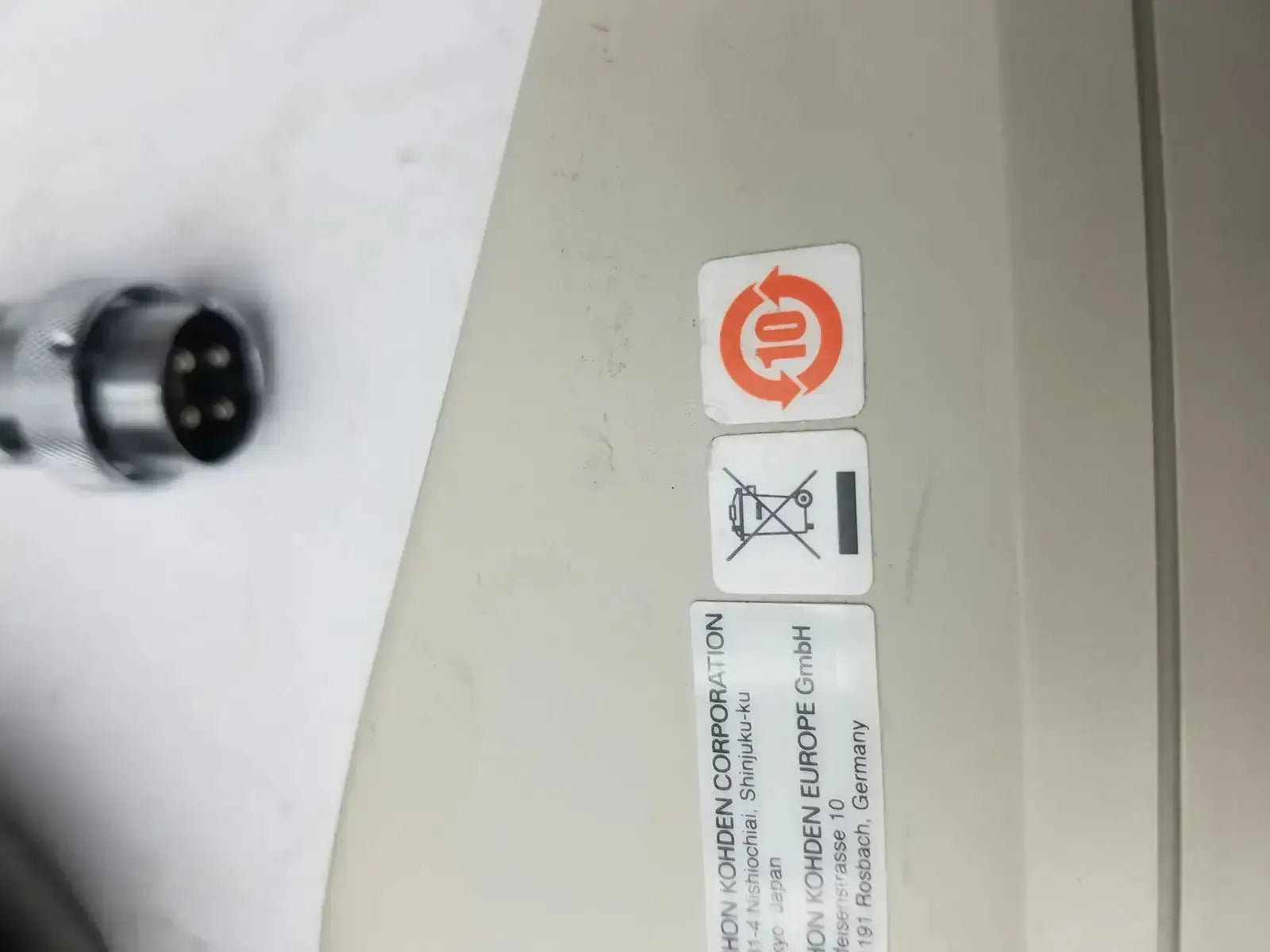 Beige plastic nihon kohden ls-703a photic stimulator showing orange recycling symbol and black disposal warning label on back