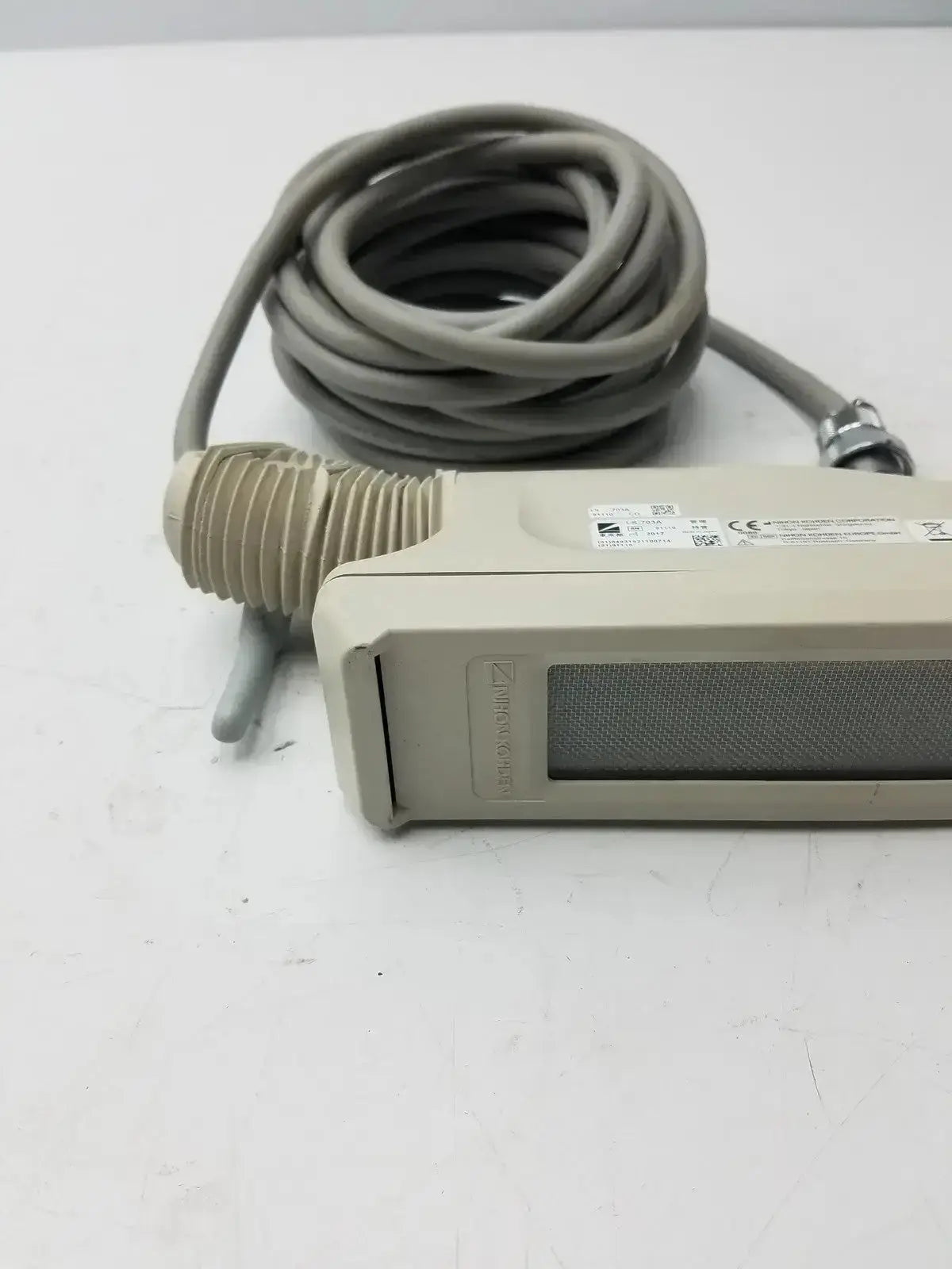 Beige rectangular nihon kohden ls-703a photic stimulator sensor with coiled gray cable and ribbed connector for medical use