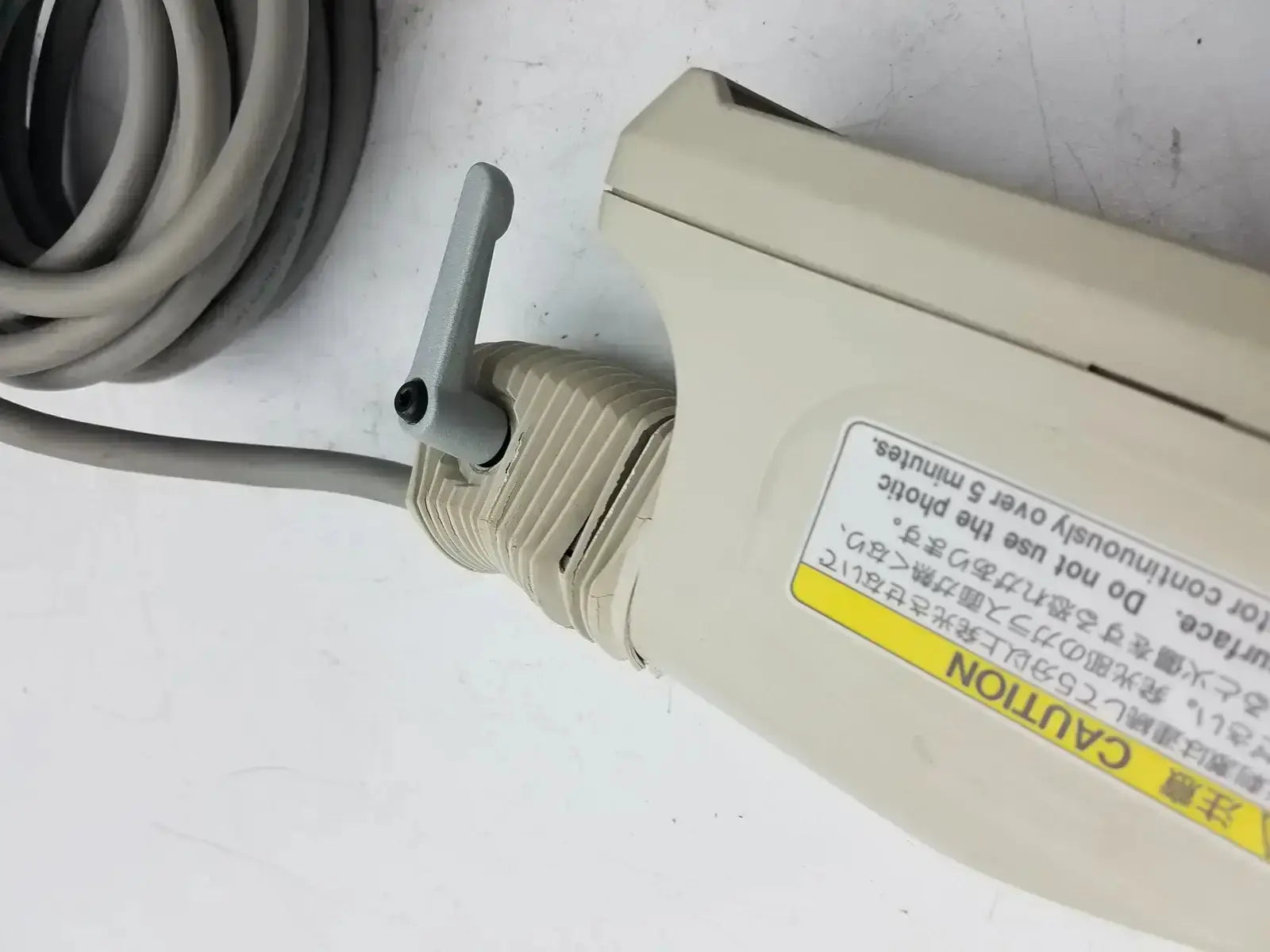 Beige plastic phonic surface probe with gray coiled cable and small handle for nihon kohden ls-703a photic stimulator