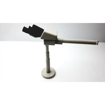 Beige dual eyepiece stereo microscope with black objective lenses and a telescoping arm.