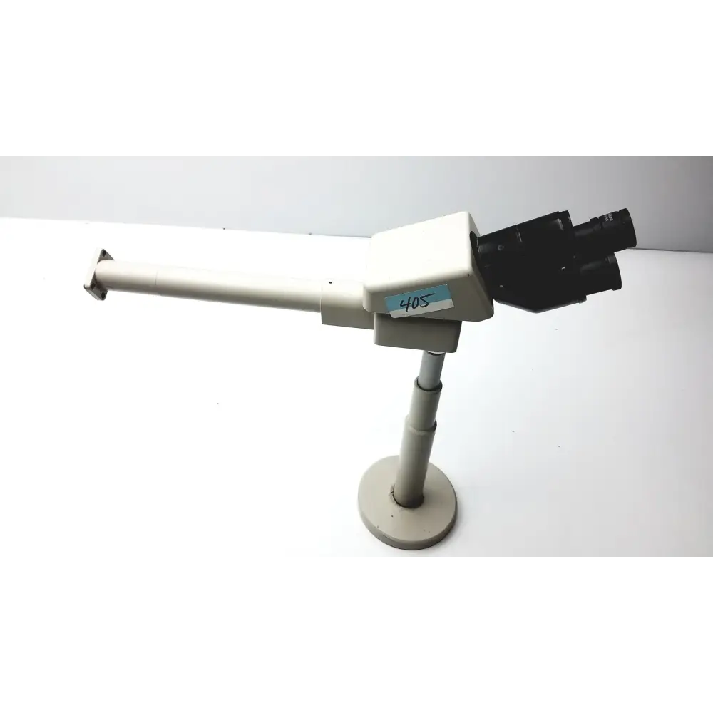Beige and black stereo microscope with adjustable arm mounted on a circular base.