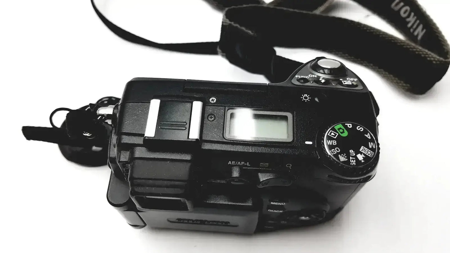 Black Nikon Coolpix E8400 digital camera with textured strap and visible control dials for reliable monitoring