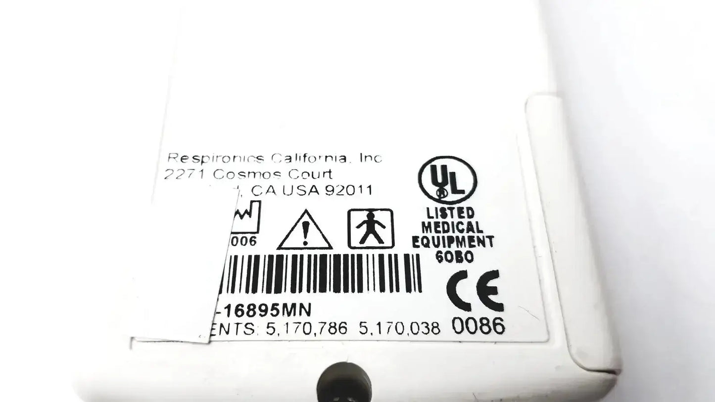 White plastic pulse oximeter monitor labeled respironics california inc with regulatory markings and barcode back side