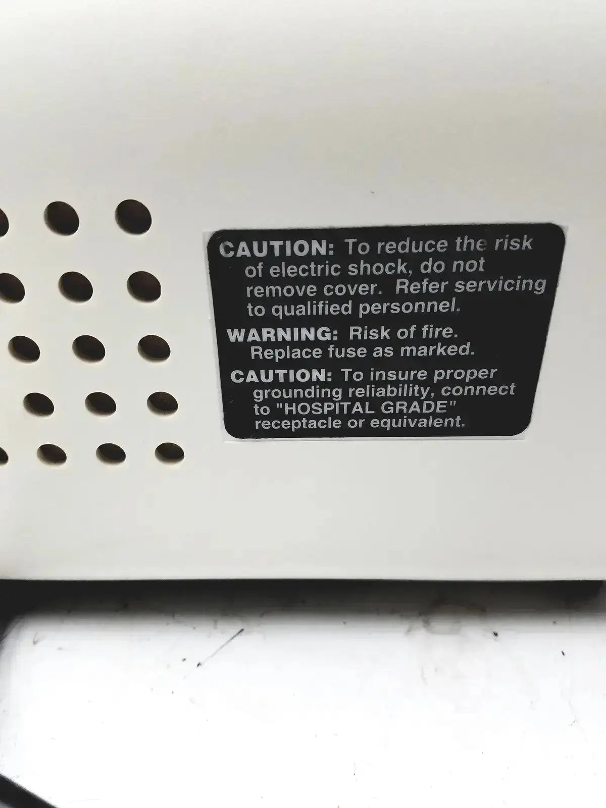 White plastic ohio medical care-e-vac 3 portable aspirator suction pump back with black safety label and ventilation holes