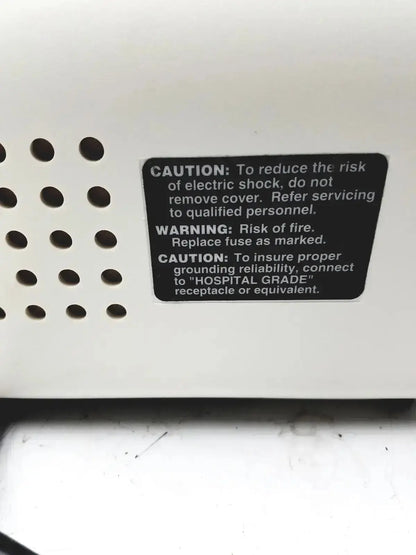 White plastic ohio medical care-e-vac 3 portable aspirator suction pump back with black safety label and ventilation holes