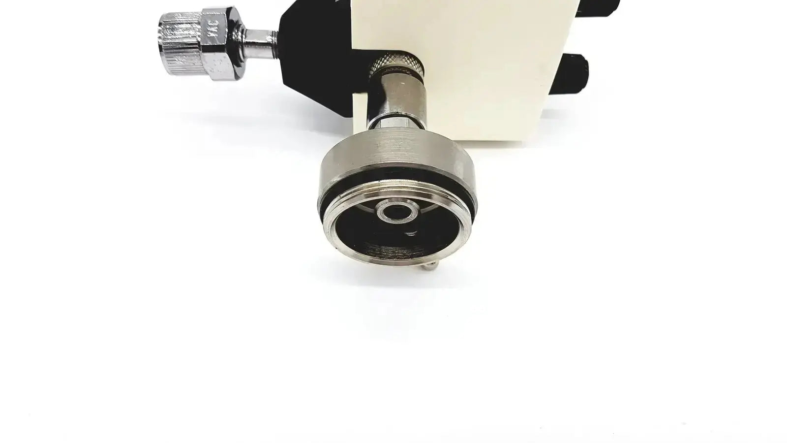 Silver metallic connector with threaded ends and black rubber seal attached to beige housing of ohmeda ffa19643 intermittent unit