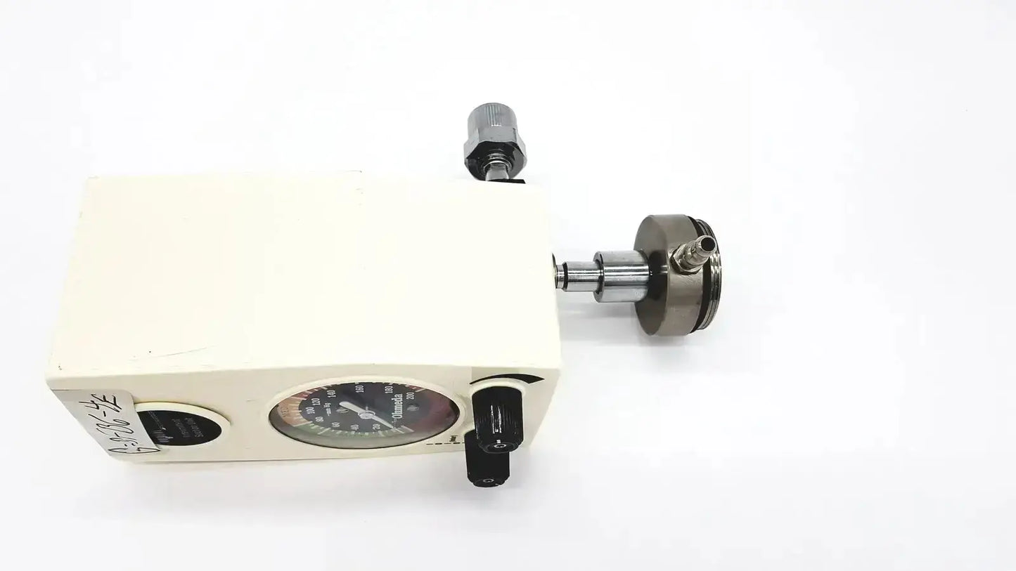 Cream-colored ohmeda ffa19643 intermittent unit oxygen flow meter with circular gauge and metallic fittings